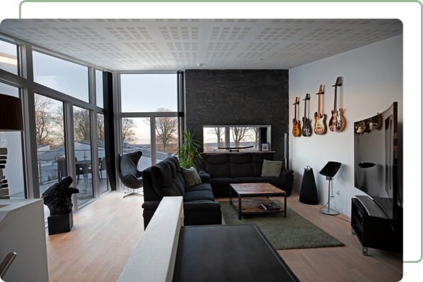 a hangout room with guitars on the wall and a large window wall