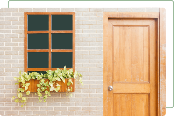 window next to a closed door in a brick wall